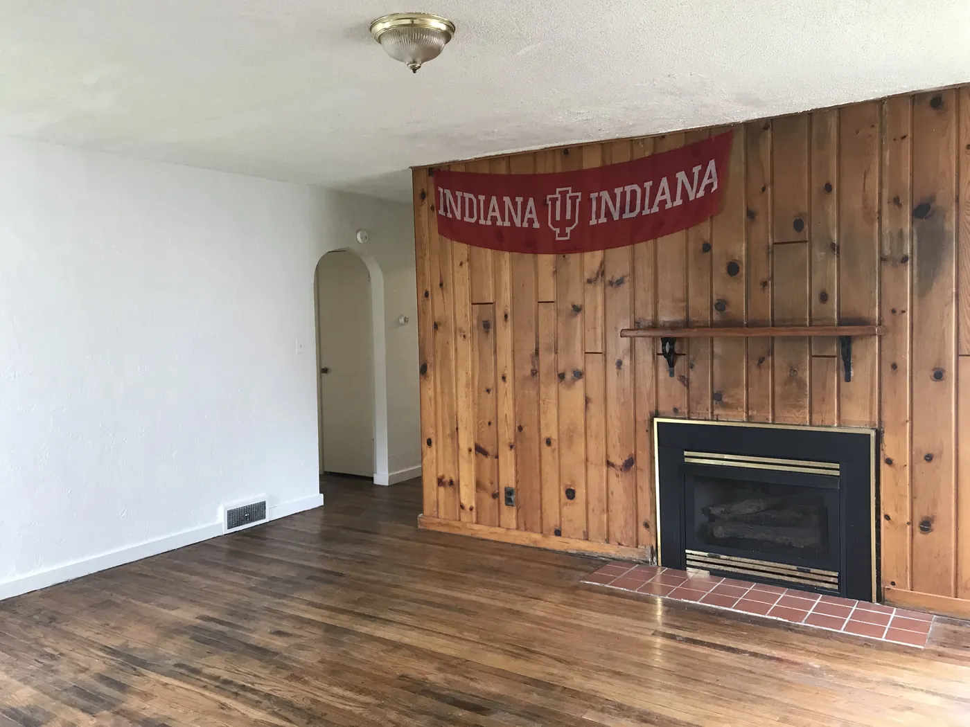Living room with hardwood floors, knotty-pine wall and fireplace