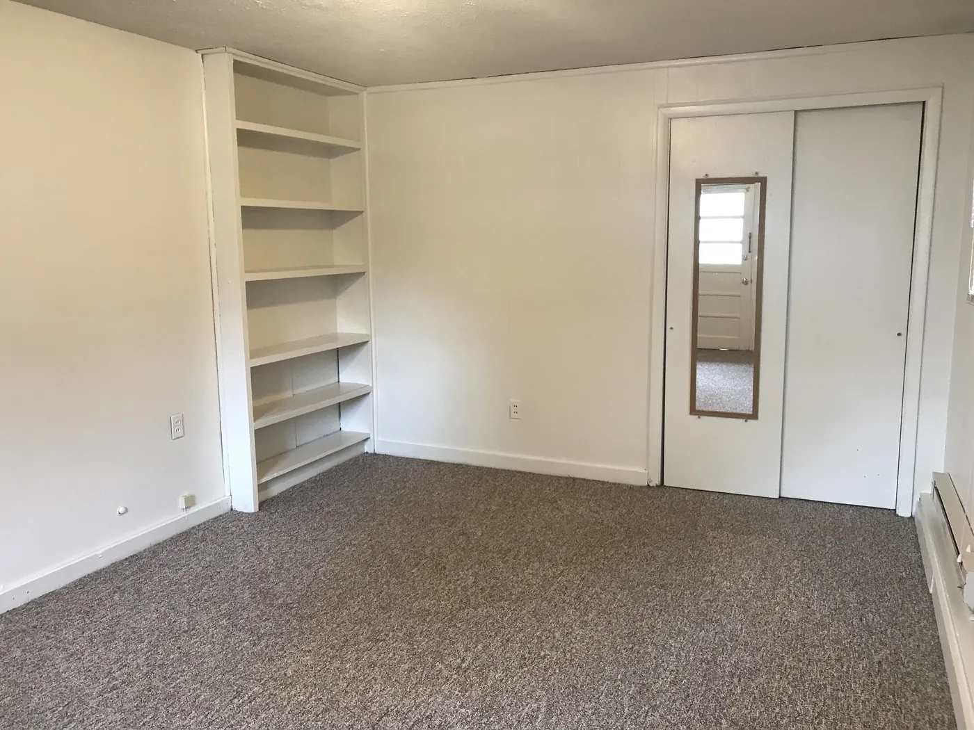 Bedroom with built-in shelves and double closet